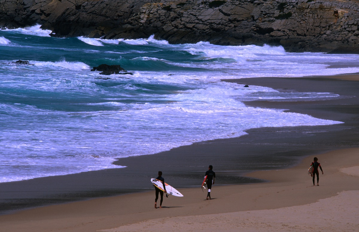 Surfers heading out to the breaks off Praia do Guincho.