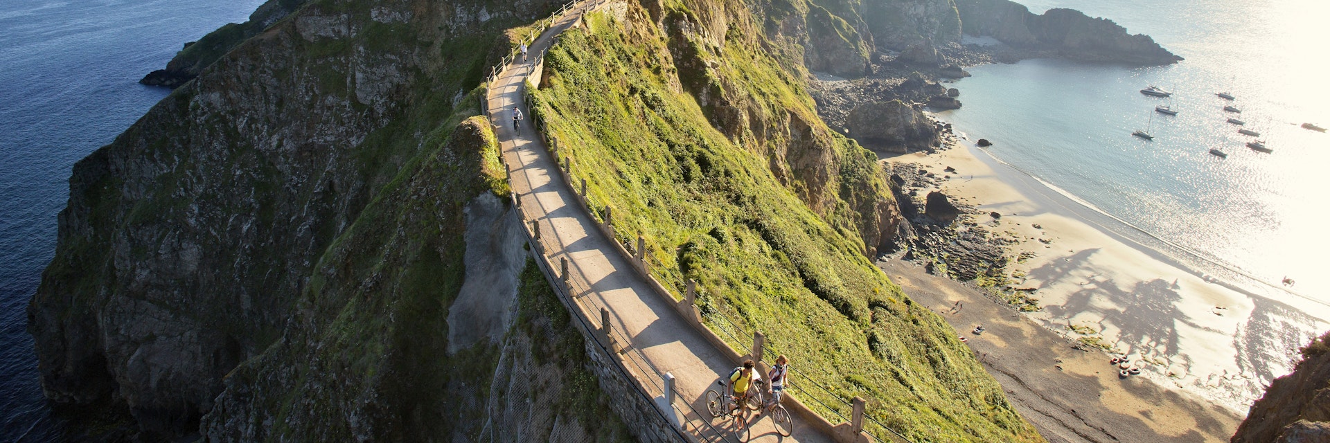 Cyclists on La Coupee; narrow isthmus that connects Big Sark to Little Sark.