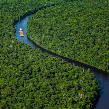 A tug pushes two barges filled with bauxite through the Commewijne river in Commewijne, Suriname. For more in this assignment visit: http://blog.kareldonk.com/aerial-photography-for-jp-knight/