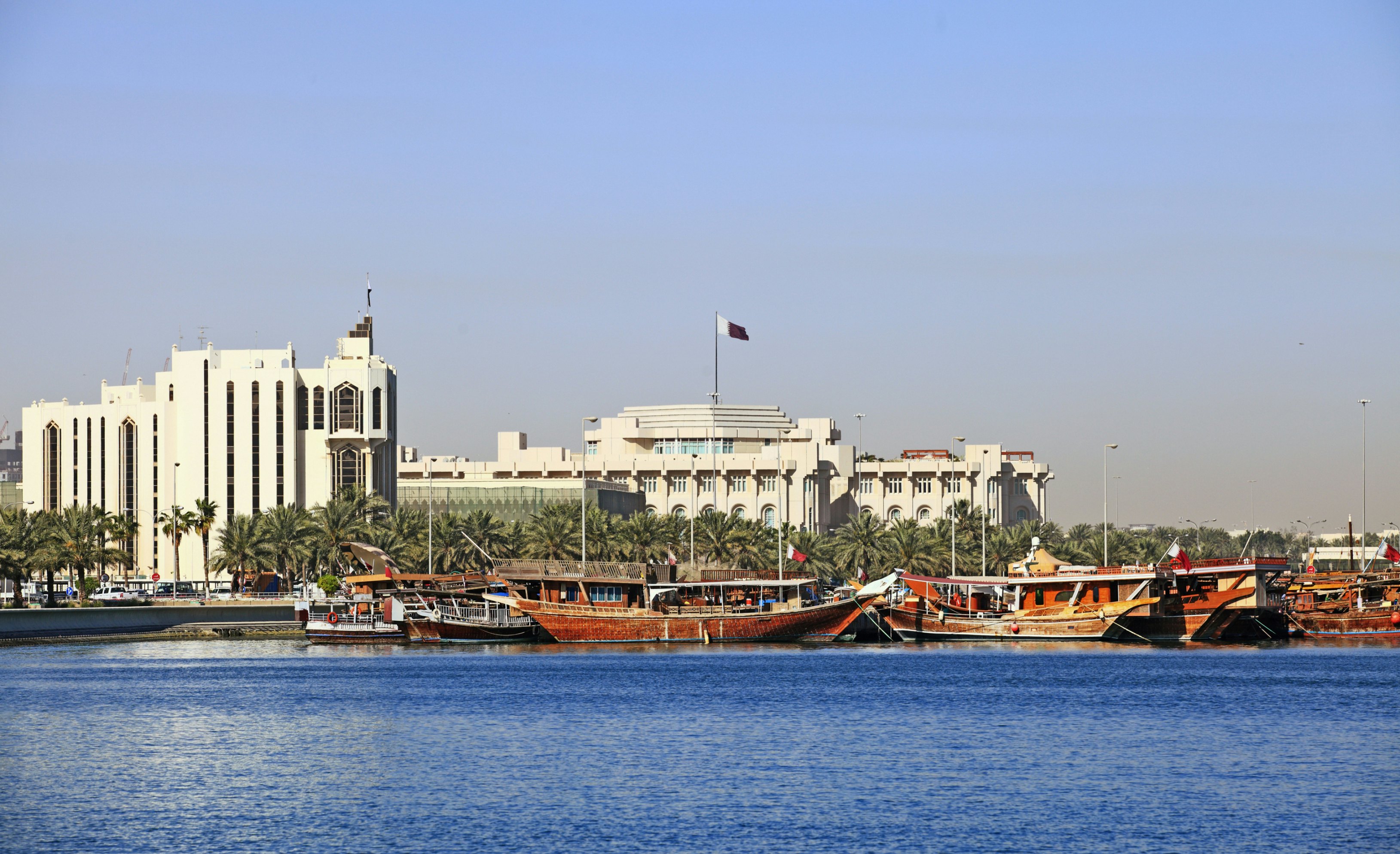 Qatar's foreign ministry (left) and Emiri Diwan ruler's administrative palace (centre with flag) seen across Doha Bay, with fishing dhows moored in front of the government buildings.; Shutterstock ID 49093879; Your name (First / Last): Lauren Keith; GL account no.: 65050; Netsuite department name: Online Editorial; Full Product or Project name including edition: Destination page image update