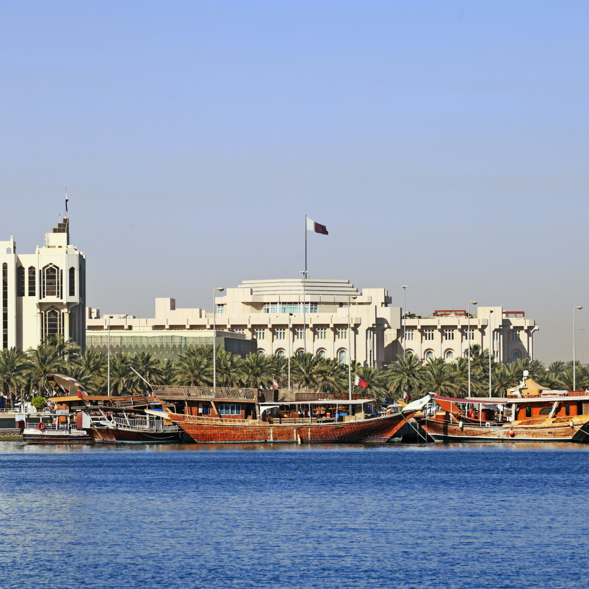 Qatar's foreign ministry (left) and Emiri Diwan ruler's administrative palace (centre with flag) seen across Doha Bay, with fishing dhows moored in front of the government buildings.; Shutterstock ID 49093879; Your name (First / Last): Lauren Keith; GL account no.: 65050; Netsuite department name: Online Editorial; Full Product or Project name including edition: Destination page image update
