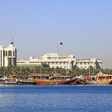 Qatar's foreign ministry (left) and Emiri Diwan ruler's administrative palace (centre with flag) seen across Doha Bay, with fishing dhows moored in front of the government buildings.; Shutterstock ID 49093879; Your name (First / Last): Lauren Keith; GL account no.: 65050; Netsuite department name: Online Editorial; Full Product or Project name including edition: Destination page image update