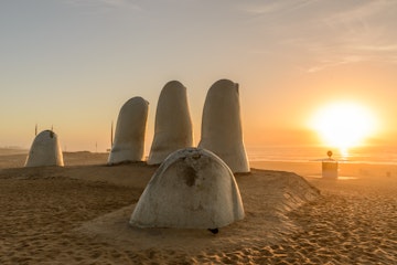 the famous sculpture "Mano de Punta del Este" by Mario Irarrázabal shot at sunrise