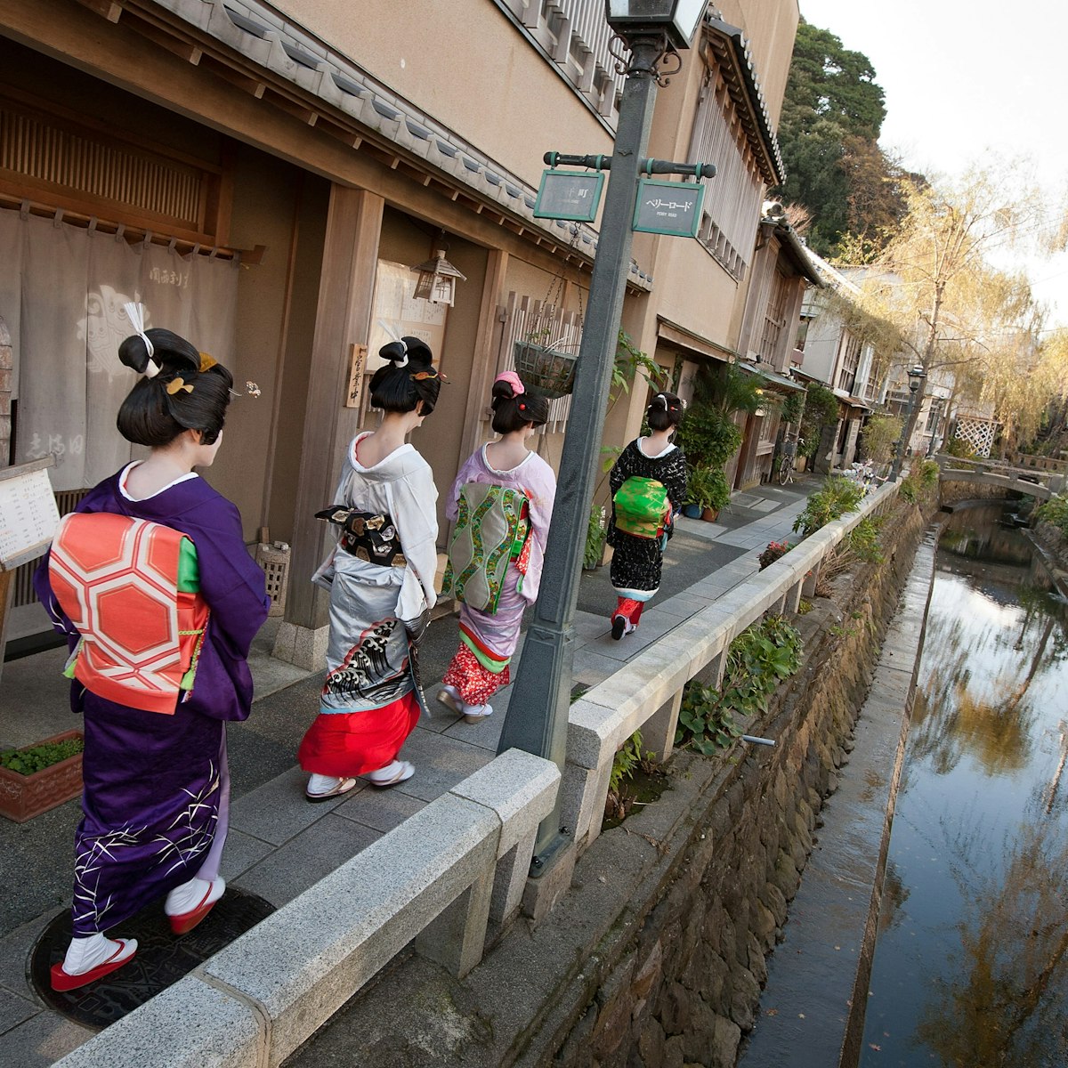 SHIMODA, JAPAN - DECEMBER 14:  Trainee geisha women, known as 'maiko', walk beside a canal on Perry Road, on December 14, 2011 in Shimoda, Japan. Shimoda, a Japanese fishing town, advertised for three women to train as geisha after their numbers fell dramatically. Once qualified in March 2012, they will work in an initiative to revive the geisha culture and rejuvenate the local tourism industry. (Photo by Jeremy Sutton-Hibbert/Getty Images)
