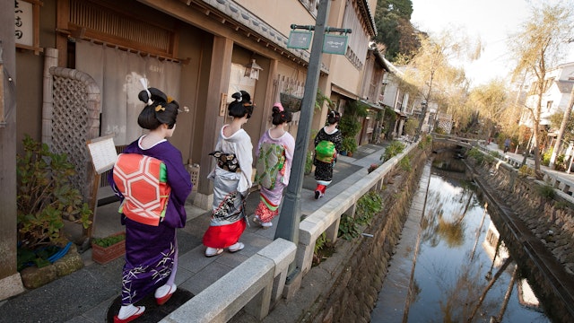 SHIMODA, JAPAN - DECEMBER 14:  Trainee geisha women, known as 'maiko', walk beside a canal on Perry Road, on December 14, 2011 in Shimoda, Japan. Shimoda, a Japanese fishing town, advertised for three women to train as geisha after their numbers fell dramatically. Once qualified in March 2012, they will work in an initiative to revive the geisha culture and rejuvenate the local tourism industry. (Photo by Jeremy Sutton-Hibbert/Getty Images)
