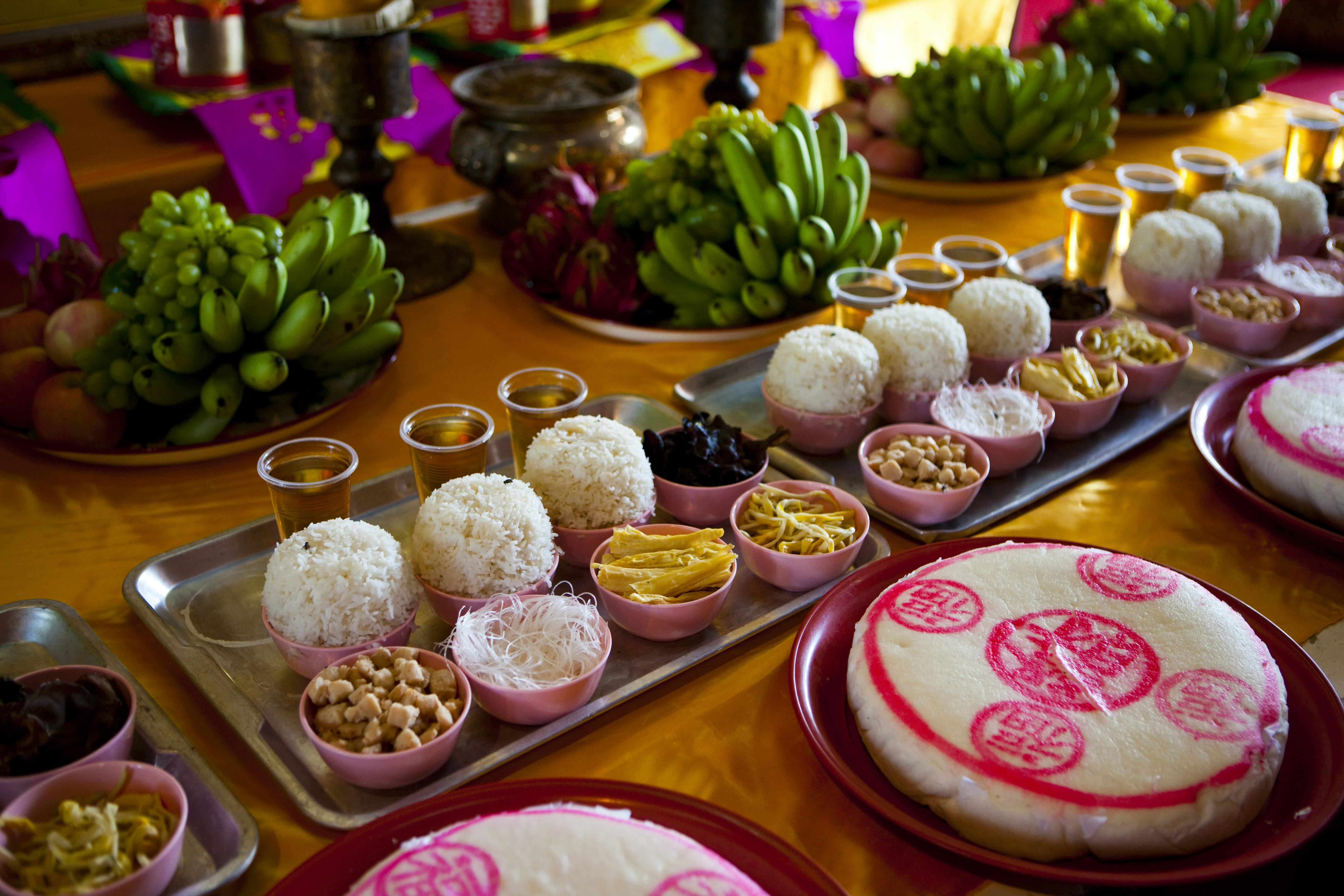 Religious food offerings on the altar at temple Wat Phanan Choeng.