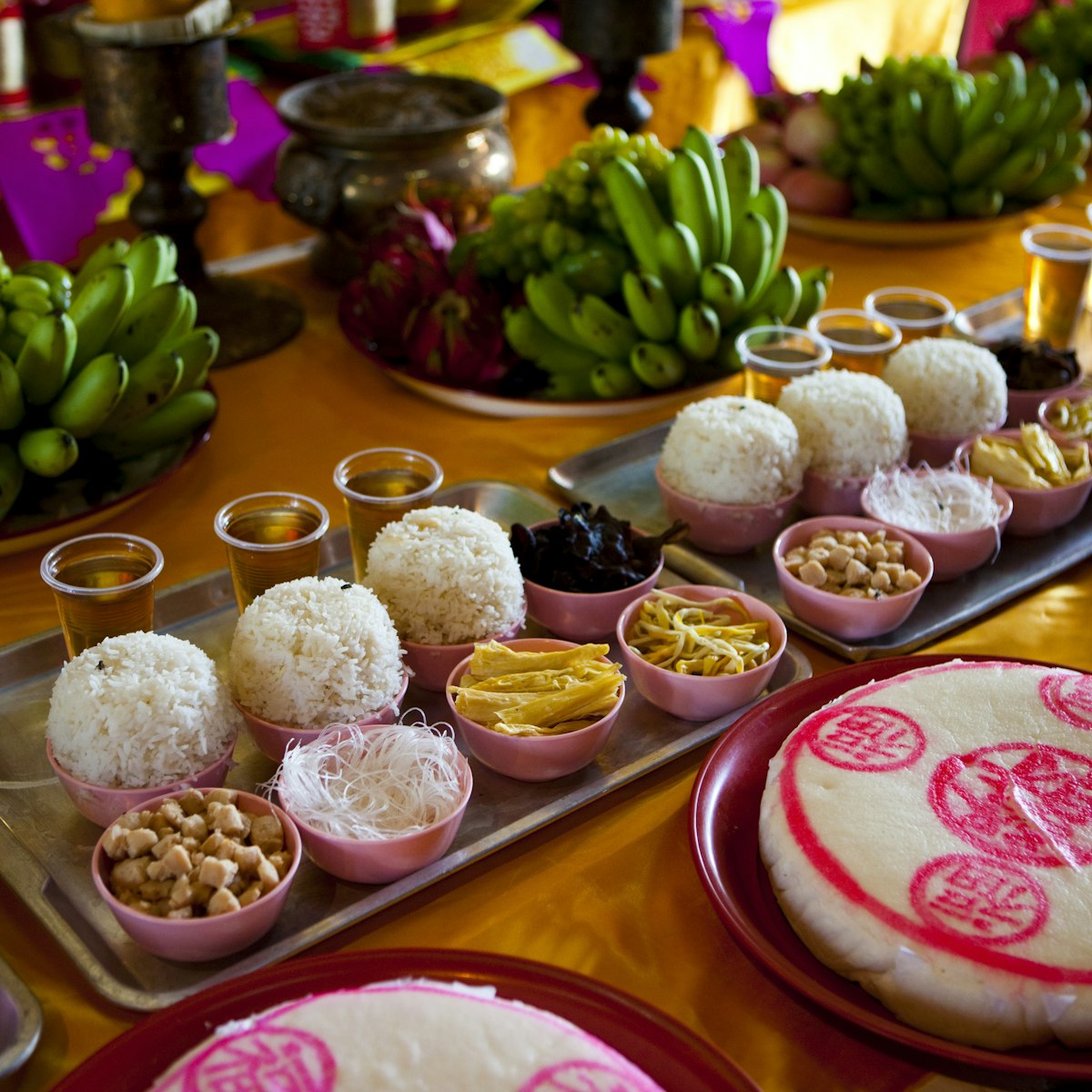 Religious food offerings on the altar at temple Wat Phanan Choeng.