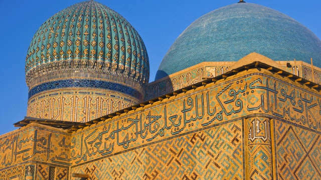 Blue-tiled domes and calligraphy-covered walls of the Yasaui Mausoleum.