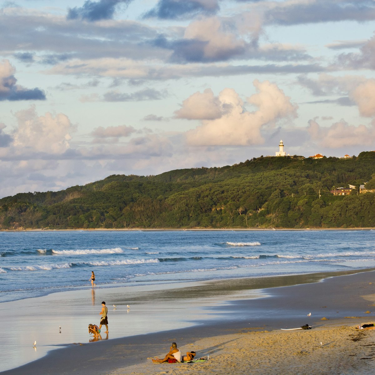 Main Beach with Cape Byron Lighthouse in background .