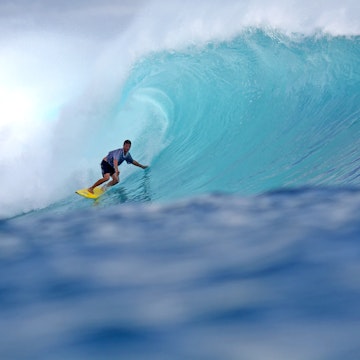 Surfer in barrel of wave.