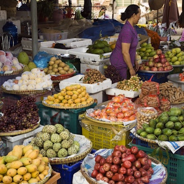 Fruit stall full of tropical fruit in market.