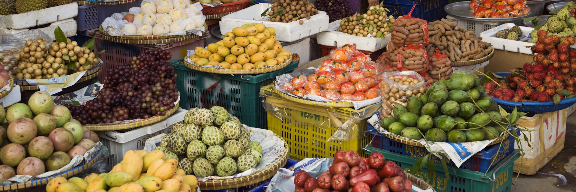 Fruit stall full of tropical fruit in market.