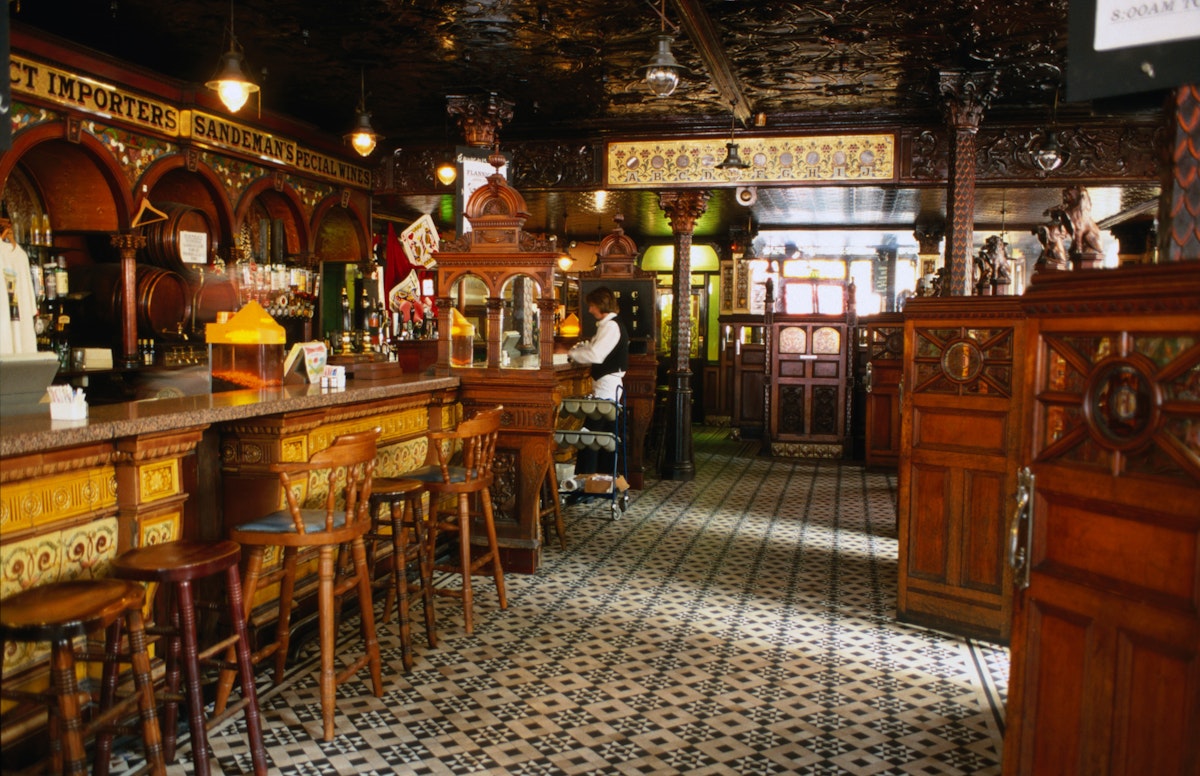 Interior of the Crown Liquor Saloon bar area which features ornate glass, tile and wooden decoration and furnishings, Belfast.