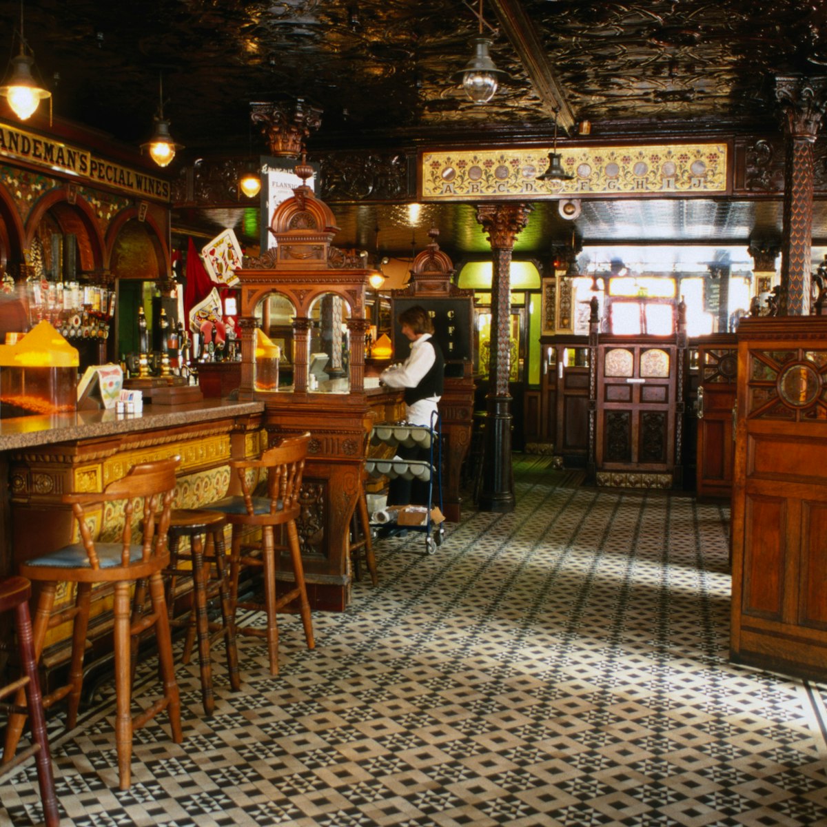 Interior of the Crown Liquor Saloon bar area which features ornate glass, tile and wooden decoration and furnishings, Belfast.