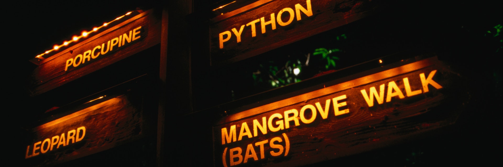 Signs illuminated at night on the Night Safari at the Singapore Zoological Gardens.