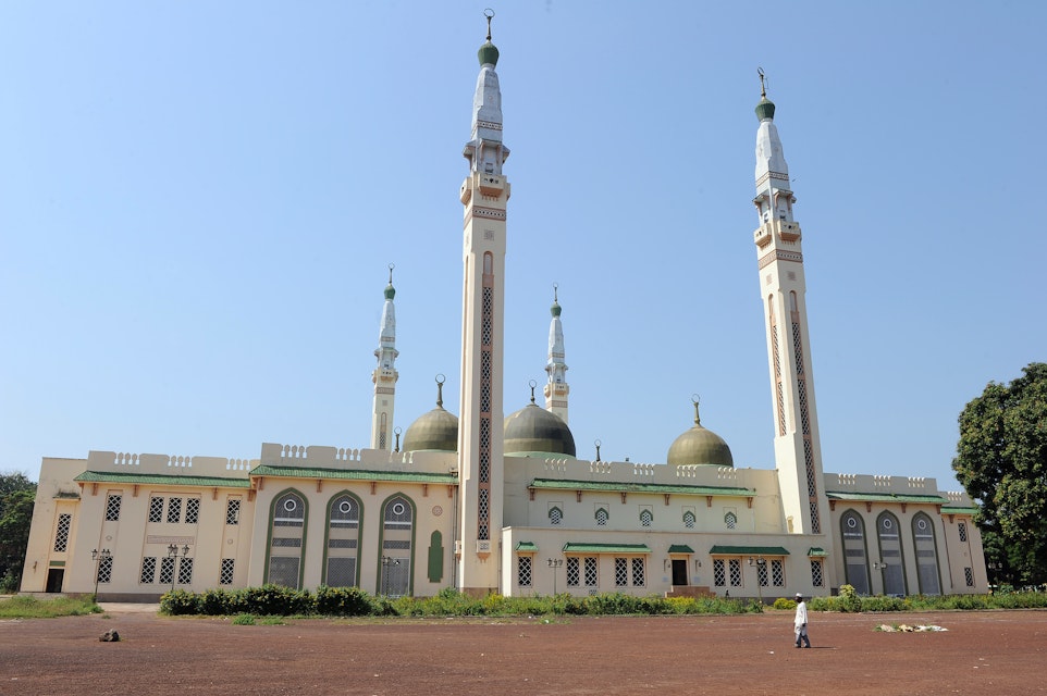 A man walks in front of the Great Mosque on December 2, 2010 in Conakry, as Guinea waited anxiously today for the Supreme Court to confirm presidential election results. Opposition leader Alpha Conde was announced the victor of Guinea's first democratic election since independence on November 15 with 52.5 percent of votes over rival Cellou Dalein Diallo who scored 47.5 percent, sparking accusations of voting fraud. AFP PHOTO / PASCAL GUYOT        (Photo credit should read PASCAL GUYOT/AFP/Getty Images)
