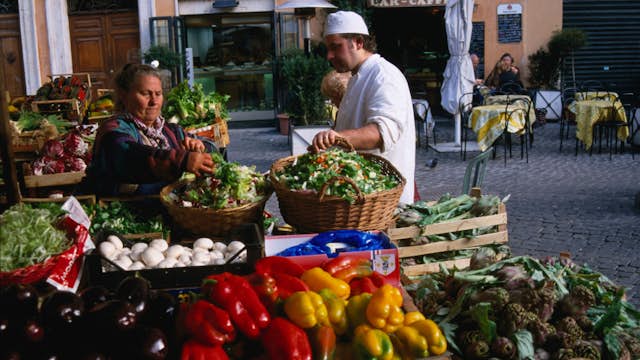 Red and yellow capsicum, egg-plants and other fresh produce at an outdoor fruit and vegetable stall in the Campo de' Fiori market