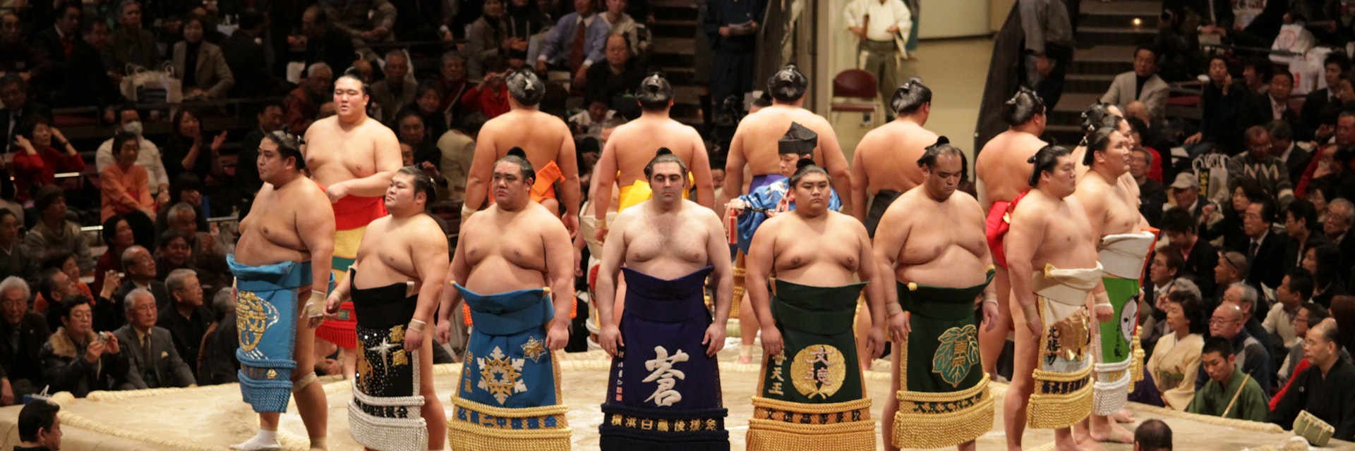 TOKYO - JANUARY 20: High rank sumo wrestlers line up with crowd in the Tokyo Grand Sumo Tournament January 20, 2009 in Tokyo, Japan.; Shutterstock ID 36619300; Your name (First / Last): Laura Crawford; GL account no.: 65050; Netsuite department name: Online Editorial; Full Product or Project name including edition: Japan page Top Experiences images