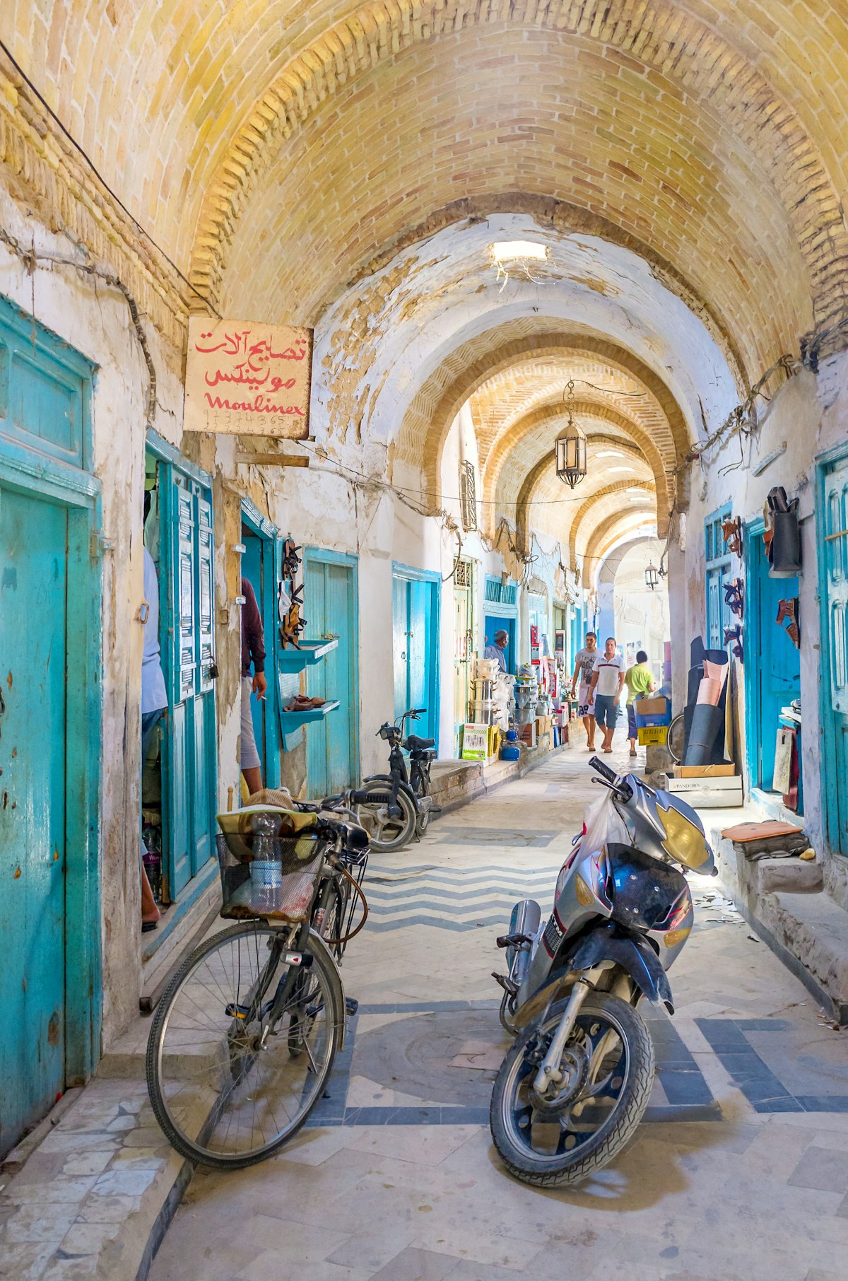 Kairouan, Tunisia - August 30, 2015: Almost all the stalls in Souq El-Blaghija market are closed after midday that's why it could be used as parking for cycles and scooters.