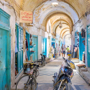 Kairouan, Tunisia - August 30, 2015: Almost all the stalls in Souq El-Blaghija market are closed after midday that's why it could be used as parking for cycles and scooters.