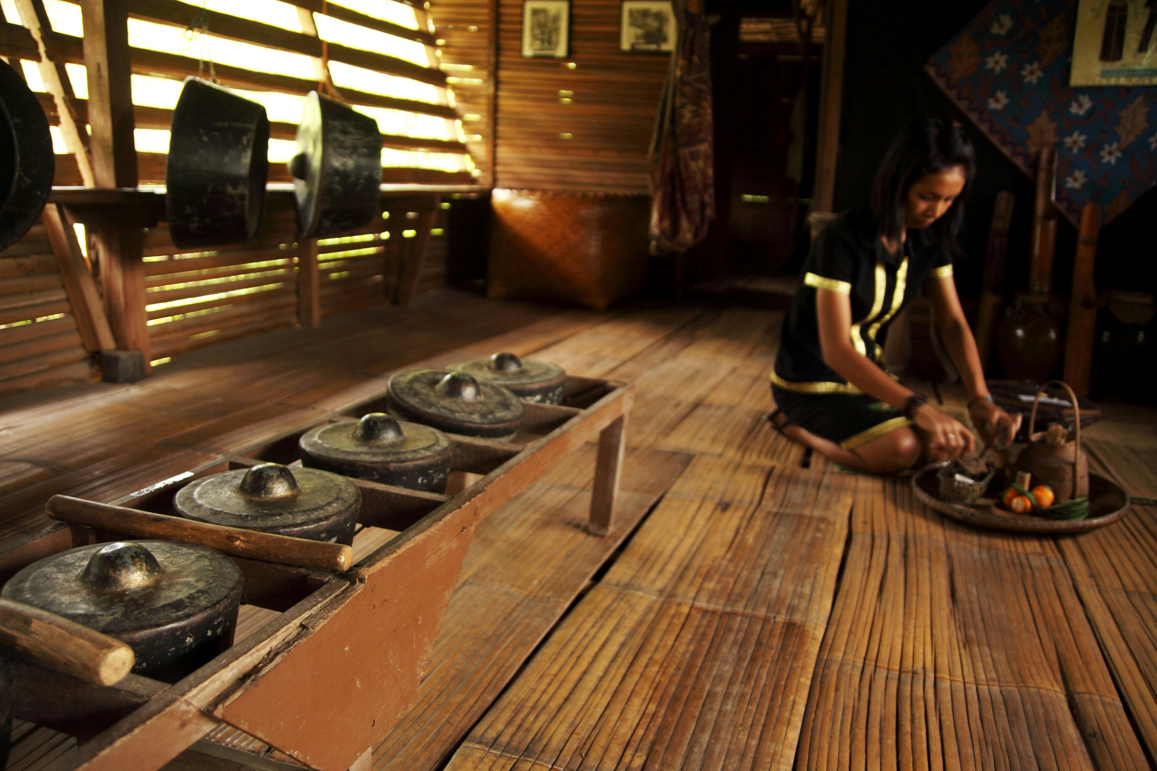 Monsopiad woman shows tourists around traditional house at Kadazan-Dusun Monsopiad Cultural Village.