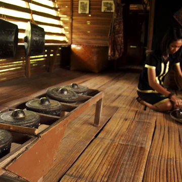 Monsopiad woman shows tourists around traditional house at Kadazan-Dusun Monsopiad Cultural Village.