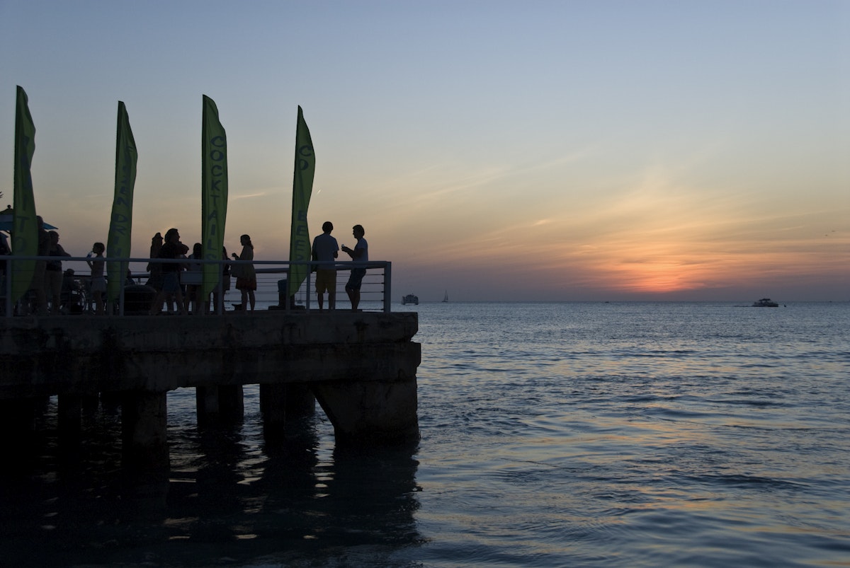 Tourists and locals enjoy cocktails while viewing the sunset from pier at Mallory Square.