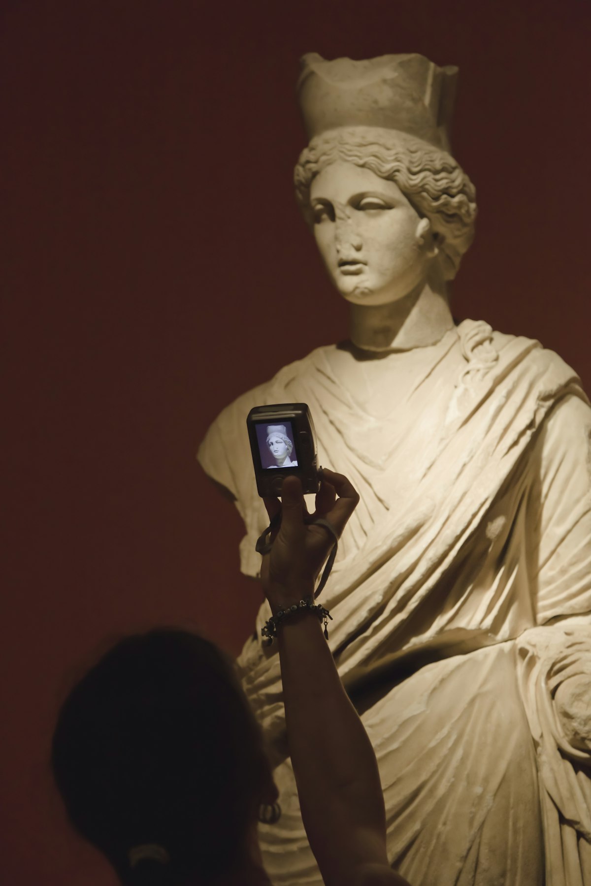 Woman photographing statue of Tyche (Fortuna).
