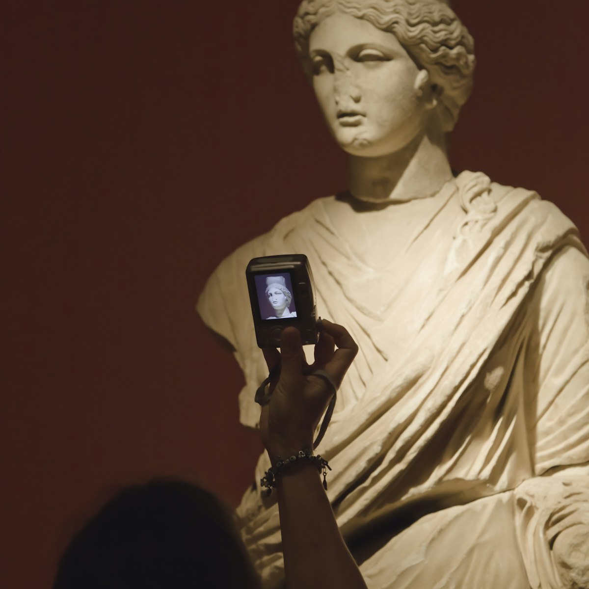 Woman photographing statue of Tyche (Fortuna).