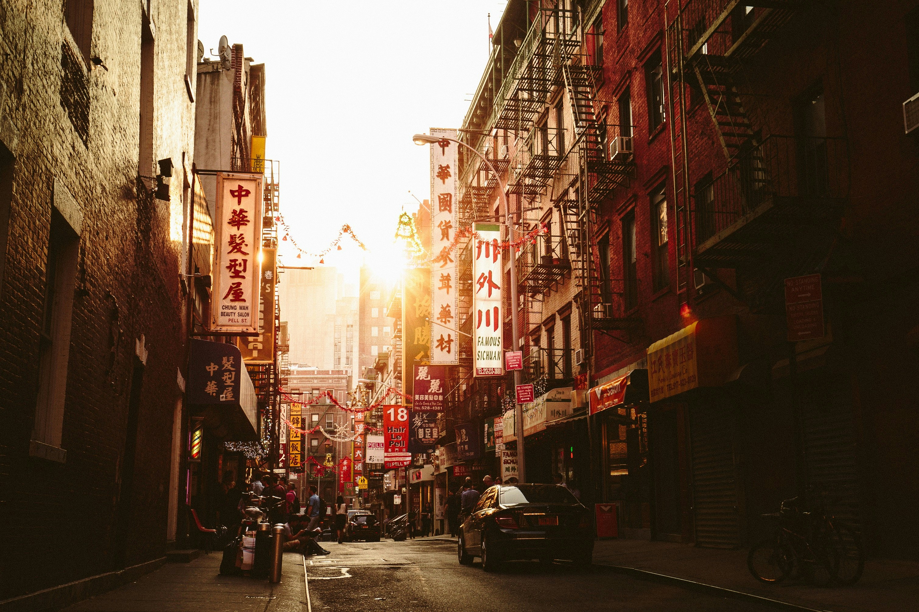 An image of a street scene at Pell Street in Chinatown / New York City / Manhattan with the setting sun.