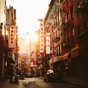 An image of a street scene at Pell Street in Chinatown / New York City / Manhattan with the setting sun.