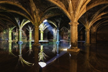 Ornate tile arches illuminated near skylight reflecting in water