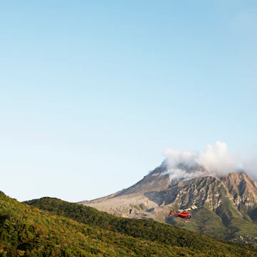 Helicopter flying near Soufriere Hills volcano.