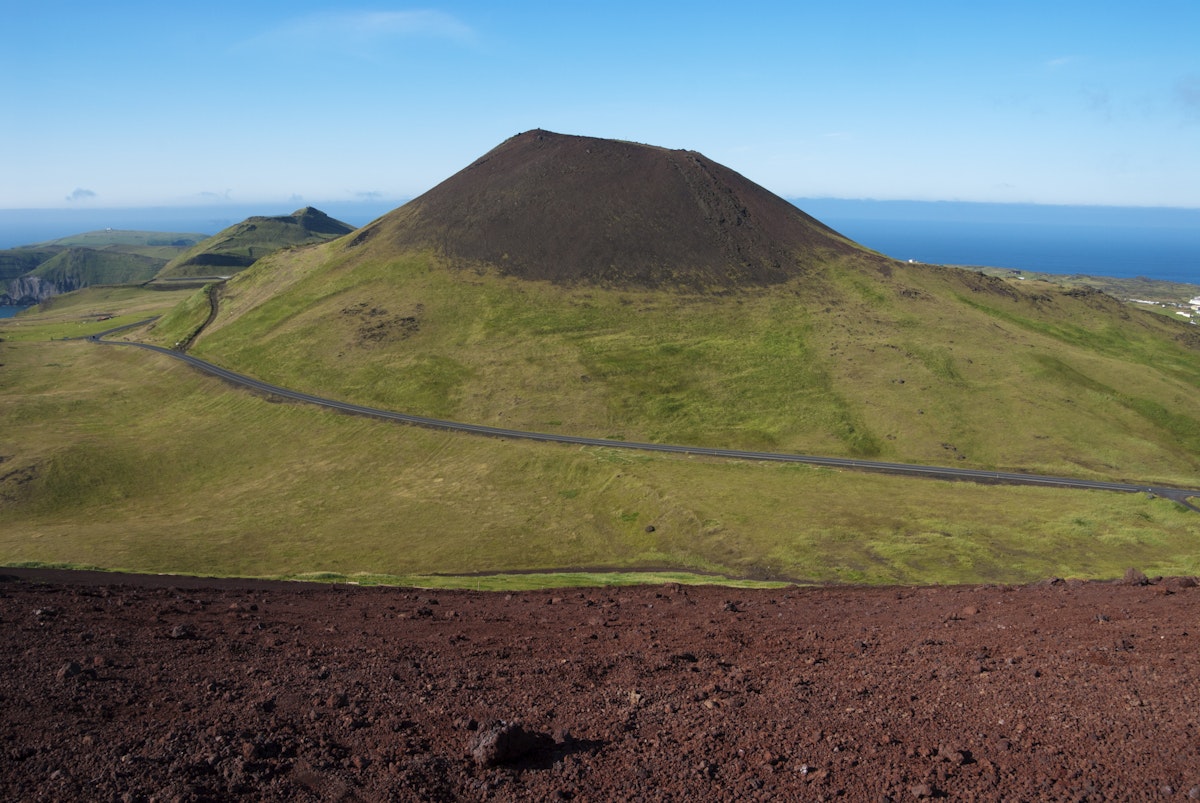 Helgafell volcano and red lava slope of Eldfell volcano on Vestmannaeyjar Island Heimaey.