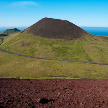 Helgafell volcano and red lava slope of Eldfell volcano on Vestmannaeyjar Island Heimaey.