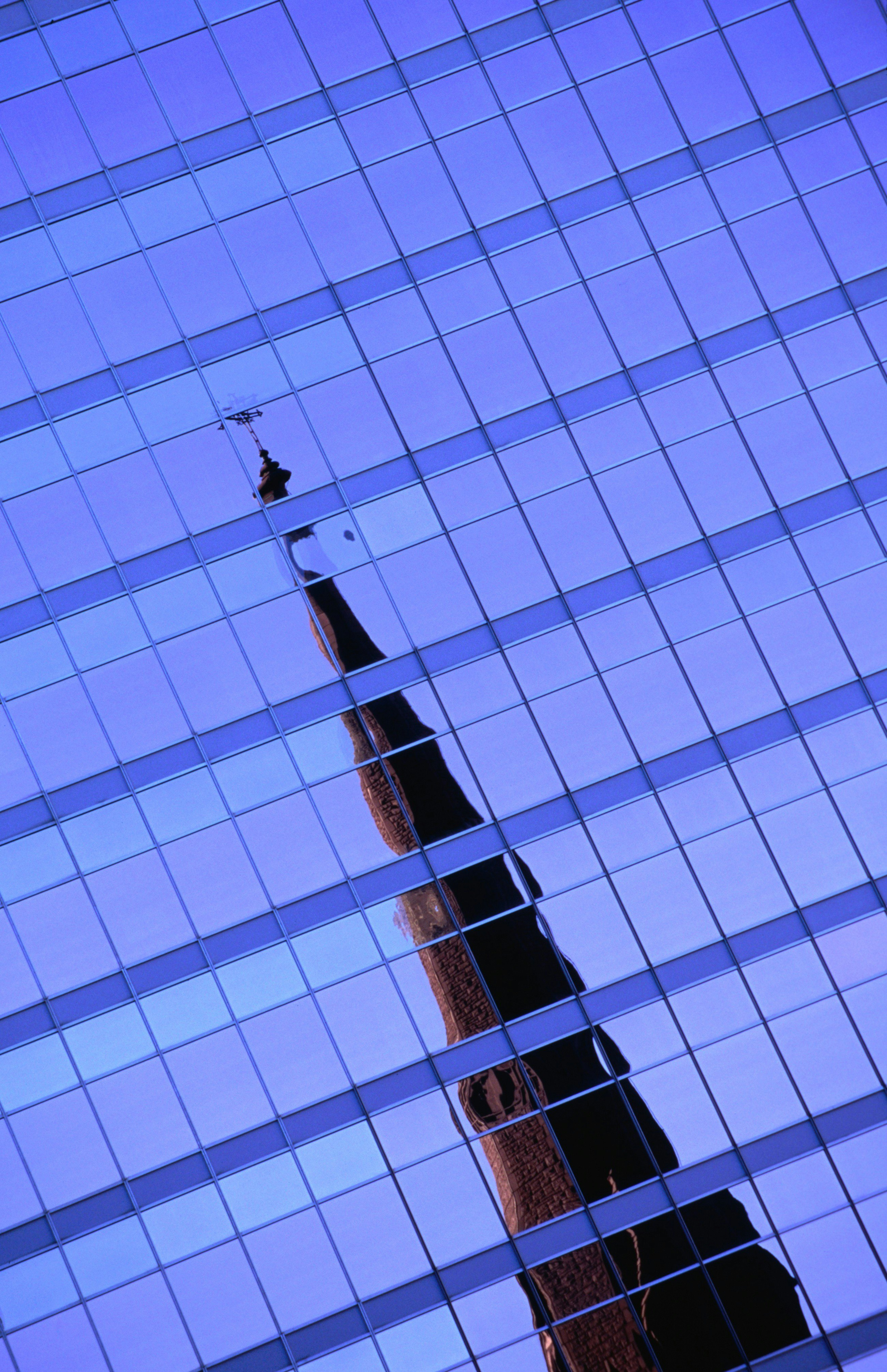 Steeple of Universite de Quebec a Montreal reflected in building.