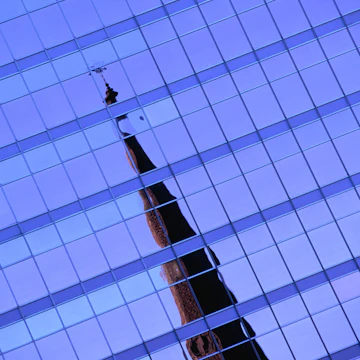 Steeple of Universite de Quebec a Montreal reflected in building.