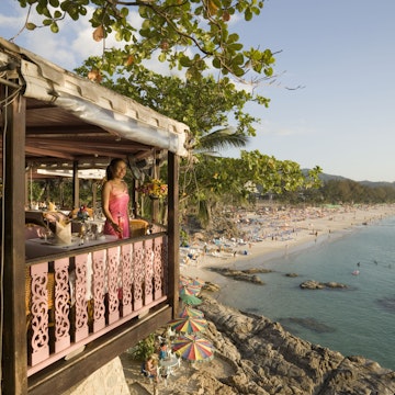 Young woman standing on terrace of Baan Rim Pa restaurant and enjoying the stunning ocean view, Patong Beach, Hat Patong, Ao Patong, Phuket, Thailand, after the tsunami