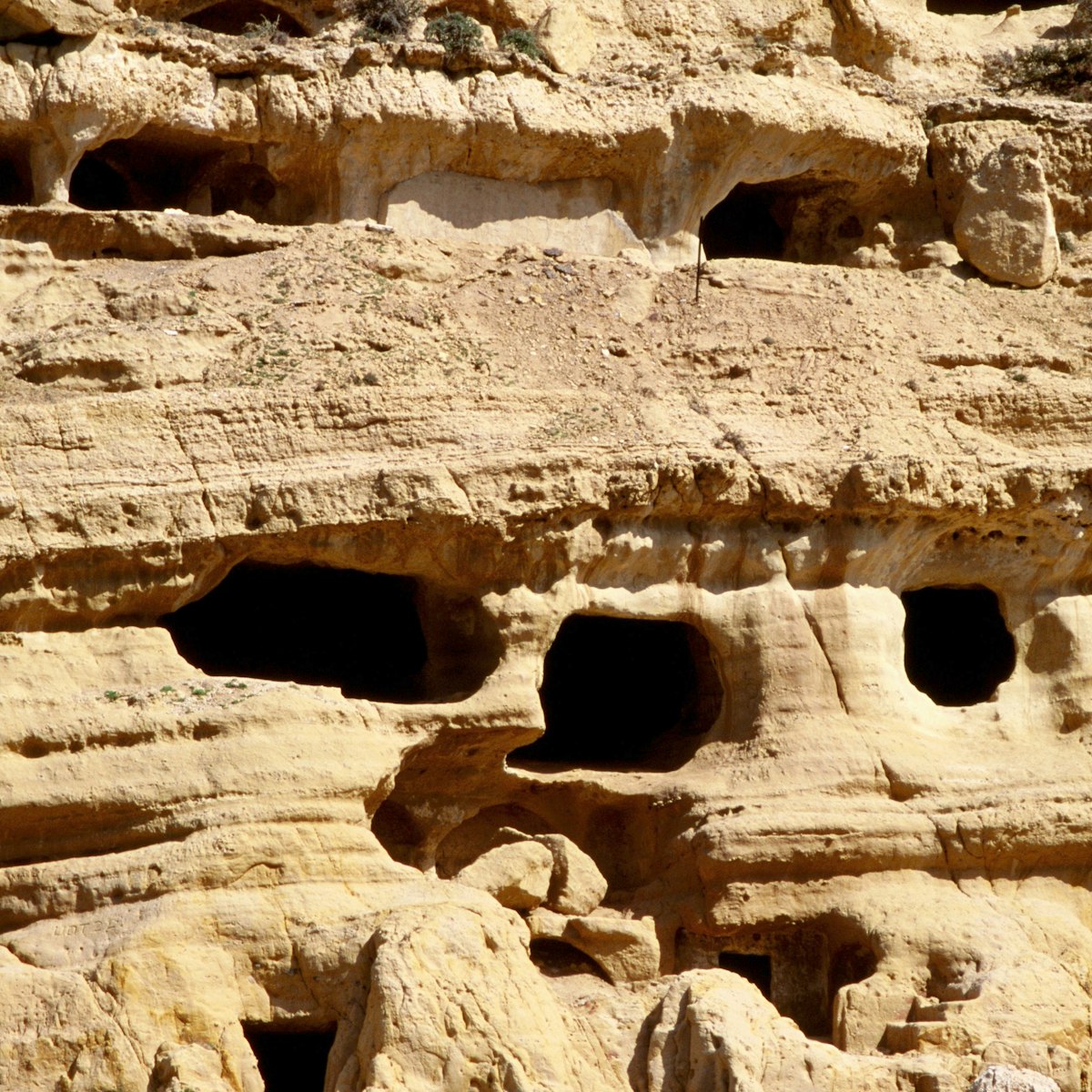 The caves in the matala cliffs started out as tombs but were used as troglodyte homes by hippies in recent years - Matala, Iraklio Province, Crete