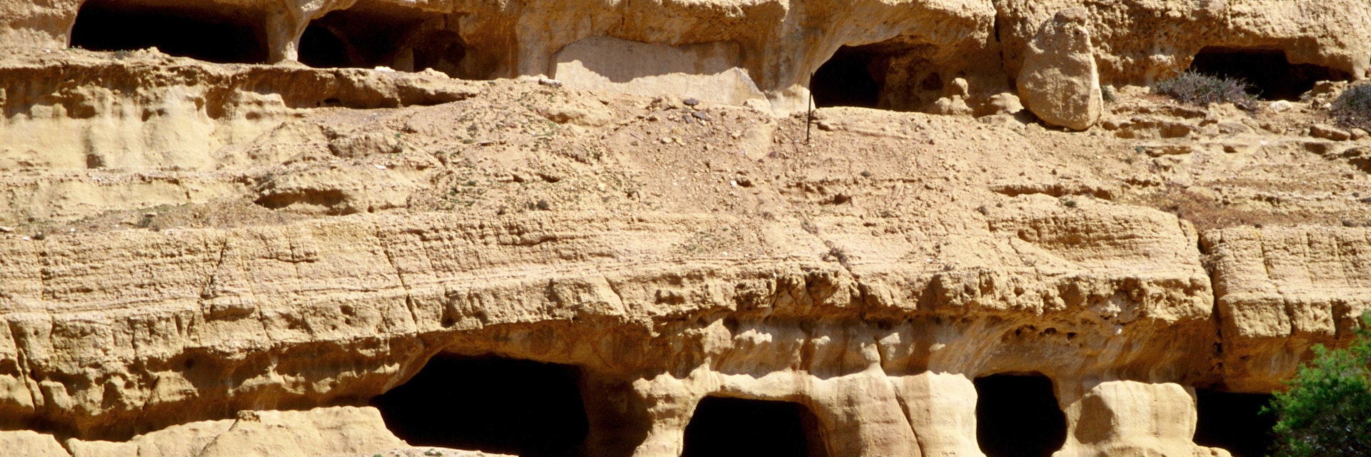 The caves in the matala cliffs started out as tombs but were used as troglodyte homes by hippies in recent years - Matala, Iraklio Province, Crete