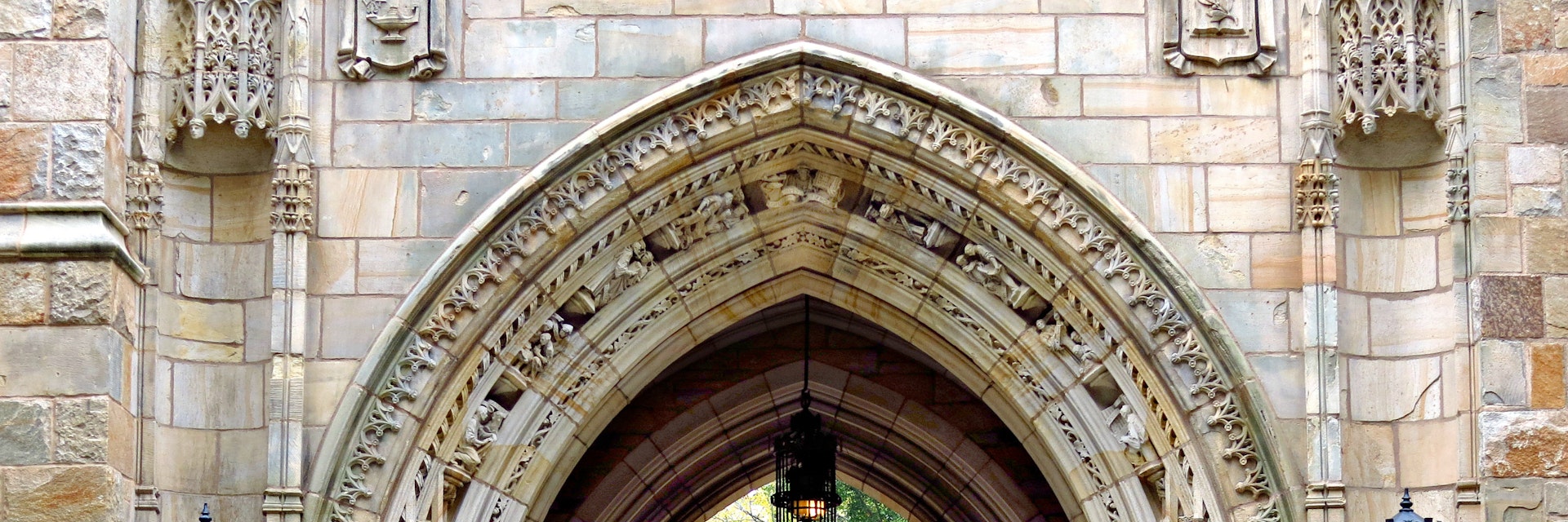 This decorative iron gate is the entrance to the Memorial Quadrangle on the campus of Yale University. The gate beneath Harkness Tower, crafted by Samuel Yellin, is the most ornate of his many works at Yale.