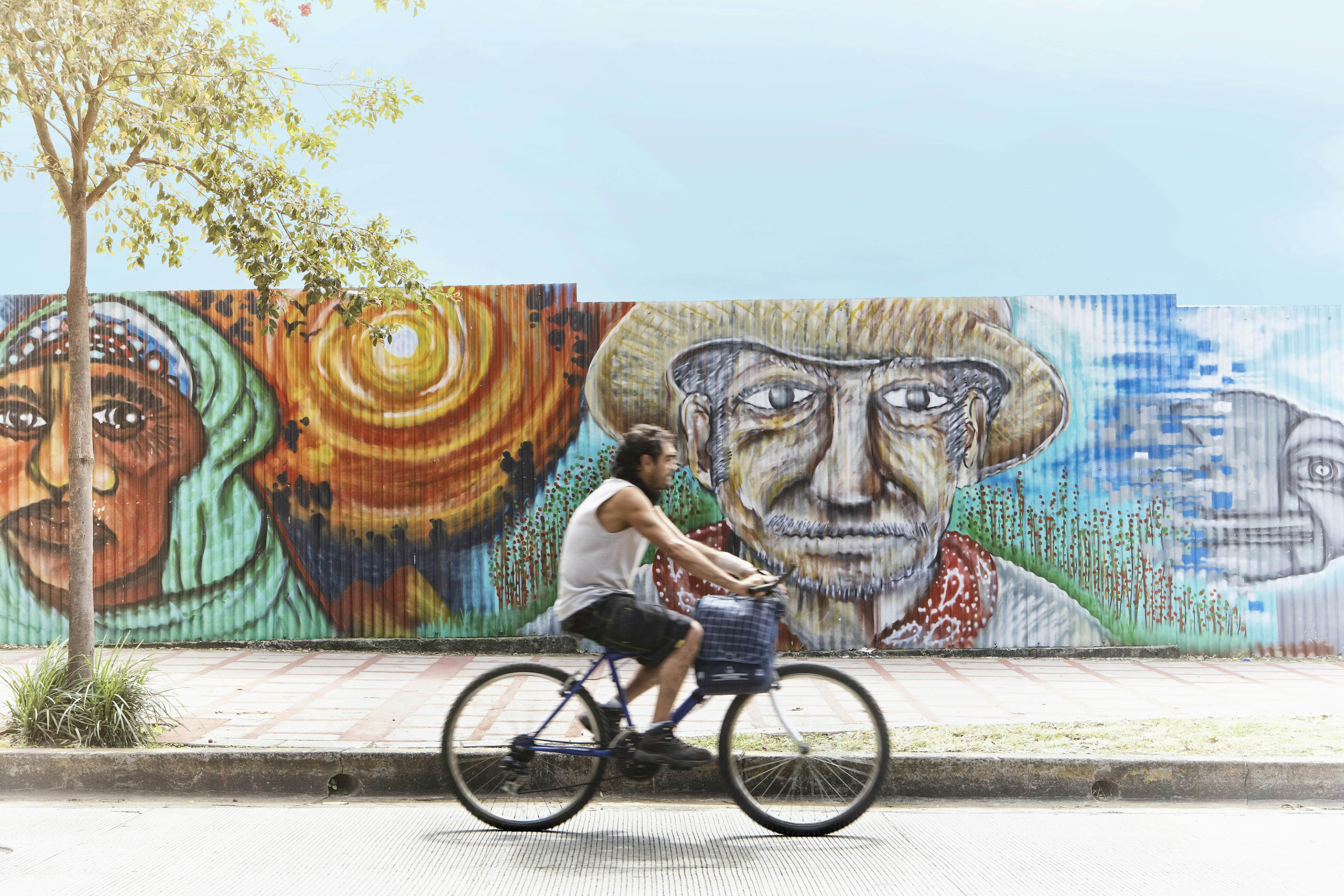 Cyclist riding past street mural.