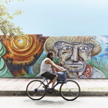 Cyclist riding past street mural.