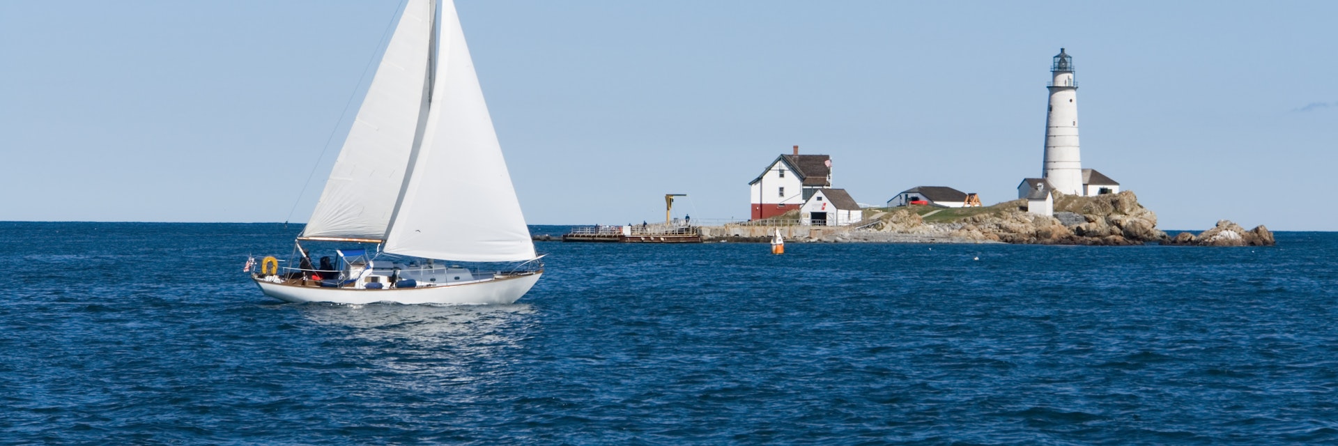 A sailboat crosses in front of Boston Light; Shutterstock ID 9570529; Your name (First / Last): Trisha Ping; GL account no.: 65050; Netsuite department name: Online Editorial; Full Product or Project name including edition: Trisha Ping/65050/Online Editorial/New England