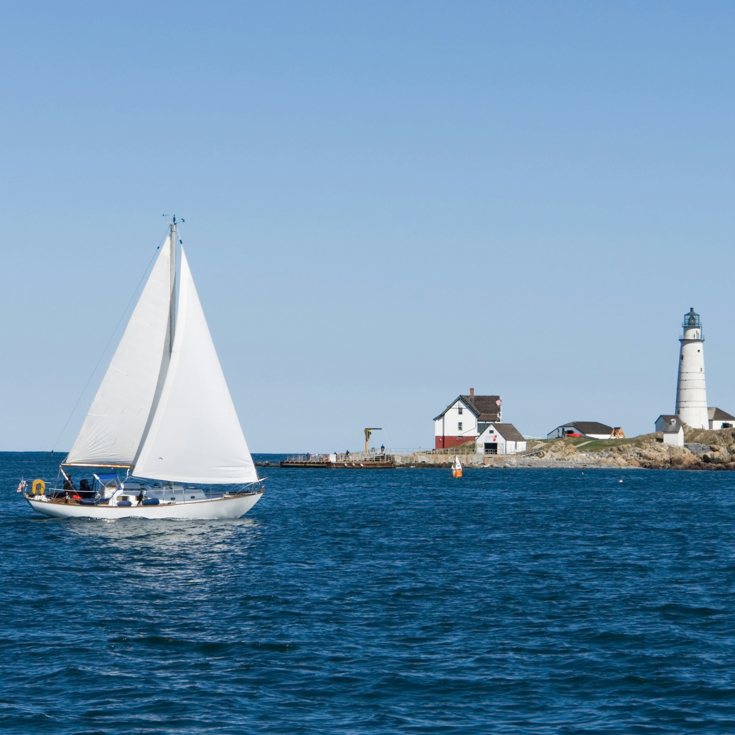 A sailboat crosses in front of Boston Light; Shutterstock ID 9570529; Your name (First / Last): Trisha Ping; GL account no.: 65050; Netsuite department name: Online Editorial; Full Product or Project name including edition: Trisha Ping/65050/Online Editorial/New England