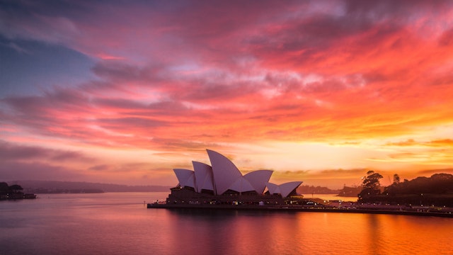 A burning dawn sky above the beautiful Sydney Opera House.