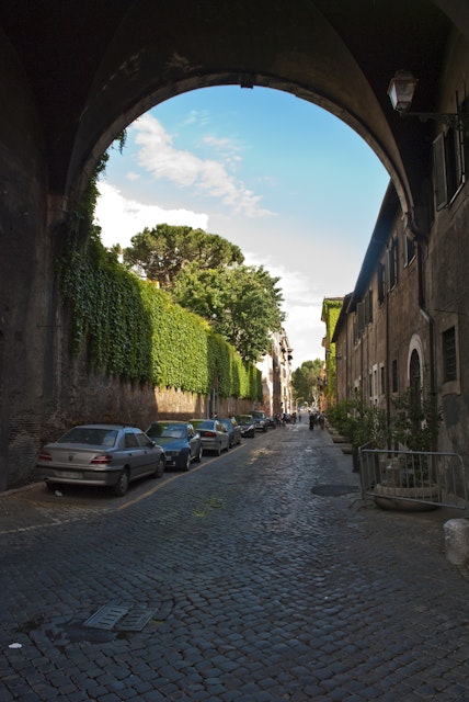 Via Giulia in Centro Storico underneath the Arco Farnese, looking along the ivy clad walls of the Palazzo Farnese on the left.