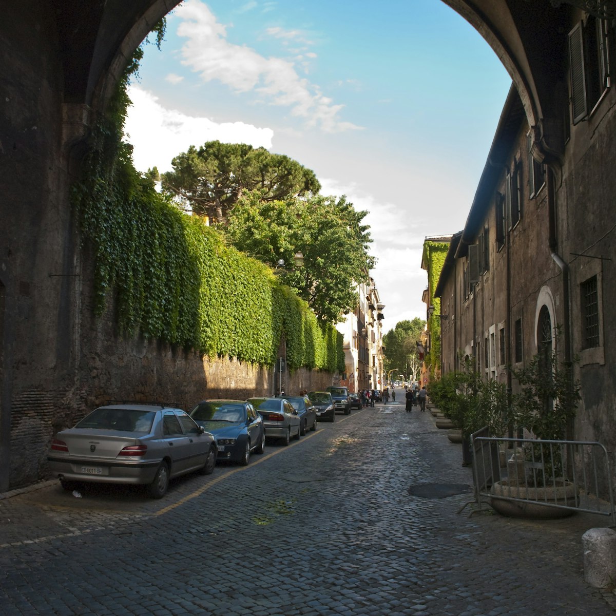 Via Giulia in Centro Storico underneath the Arco Farnese, looking along the ivy clad walls of the Palazzo Farnese on the left.