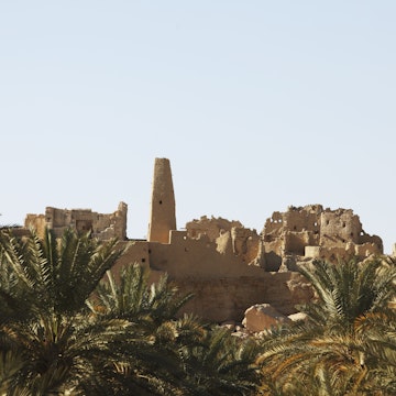 Temple of the Oracle (left) amongst ruined mud buildings.
