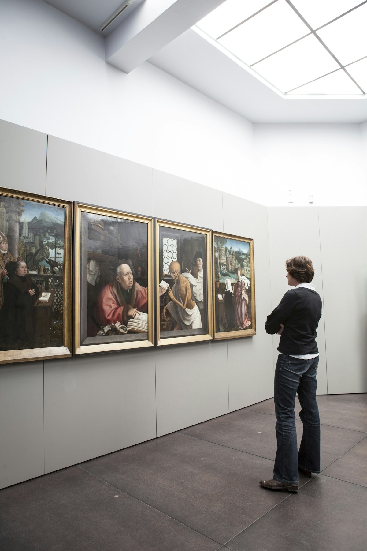 Woman viewing paintings (Hugo Van der Goes - St Hippolyte's Triptich) at Groeningemuseum.